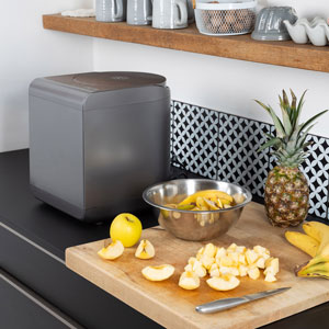 composteur électrique à coté de pommes et bananes découpées